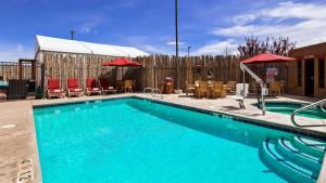 una gran piscina con sillas y sombrillas en Inn at Santa Fe, SureStay Collection by Best Western en Santa Fe