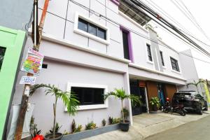 a white building with palm trees in front of it at Wisma Surya in Pangkalanuringin