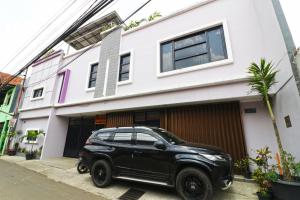 a black car parked in front of a house at Wisma Surya in Pangkalanuringin