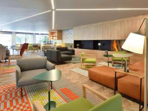 ワーヴルにあるNovotel Wavre Brussels Eastのロビー(椅子、テーブル、暖炉付)