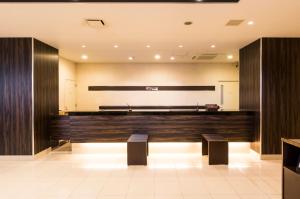 an empty courtroom with two benches and a stage at Dormy Inn Express Mikawaanjo in Anjomachi