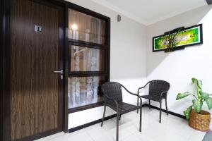 two chairs and a door in a room at Wisma Surya in Pangkalanuringin