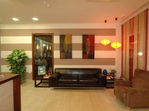 uma sala de estar com um sofá de couro preto num quarto em Hotel Las Canteras de Puerto Real em Puerto Real