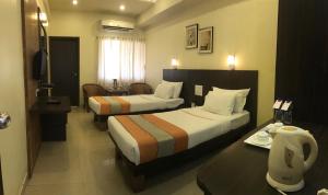 Postel nebo postele na pokoji v ubytování Hotel Atria, Kolhapur