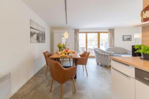 - une cuisine et une salle à manger avec une table et des chaises dans l'établissement Ferienhaus Dierhagen am Deich, à Dierhagen