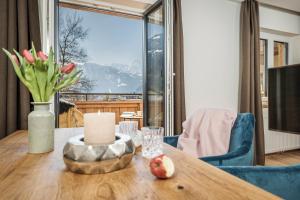 a table with a candle and a vase of flowers on it at Emma's kleines Hotel in Ramsau im Zillertal