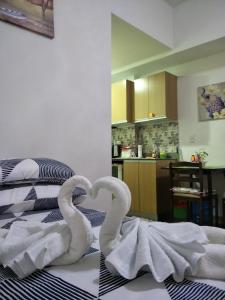 twee zwanen zitten bovenop een bed bij Zhamira Avior's Condominium in Mactan