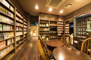 a library with a table and chairs and books at Dormy Inn Express Mikawaanjo in Anjomachi