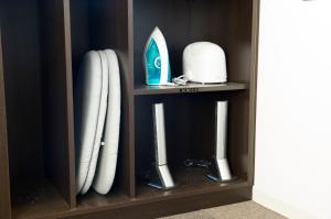 a wooden cabinet with white objects in it at Dormy Inn Express Mikawaanjo in Anjomachi