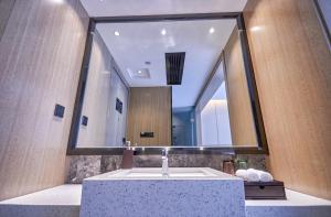 a bathroom with a sink and a large mirror at Paco Hotel Guangzhou Baiyun Airport Liantang Metro in Huadu