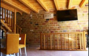 a room with a brick wall with a television and chairs at Accommodation Santor in Lastovo