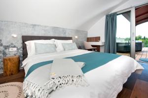 a bedroom with a large bed and a balcony at The Q - Superior Apartment in Rovinj