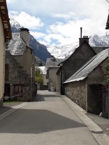 a street in a village with mountains in the background at Confortable appartement T2 cabine Loudenvielle in Loudenvielle