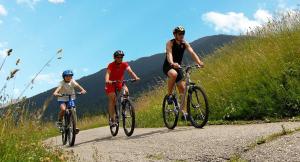 três pessoas a andar de bicicleta numa estrada de montanha em HOTEL LORENA em Toscolano Maderno
