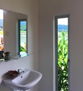 a bathroom with a sink and two windows at Kawah Padi Garden Villa Langkawi in Kuah