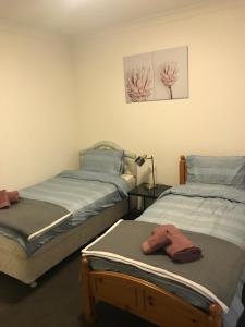 two twin beds in a room with a lamp at Elegant Design 2 Bed 2 Bath Apartment In Liverpool in Liverpool