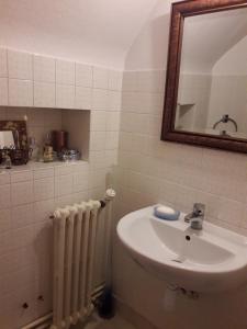 een badkamer met een wastafel, een spiegel en een radiator bij Chambre belle demeure in Gouesnou