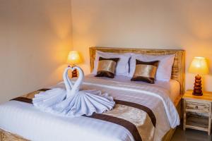 a bedroom with a swan decoration on a bed at Kayu Kuning Cottage in Nusa Penida