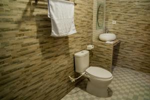 a bathroom with a toilet and a sink at Kayu Kuning Cottage in Nusa Penida +27 photos