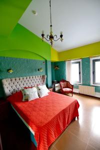 sypialnia z czerwonym łóżkiem i zieloną ścianą w obiekcie Alacati Suites w mieście Alaçatı