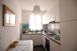 a kitchen with white cabinets and a sink and a window at 1919 in Sestri Levante