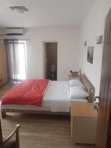 1 dormitorio con 1 cama grande con manta roja en Hotel Kiko, en Bitola