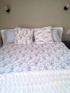 a bed with a white blanket and pillows on it at Résidence tout confort Cabestany in Cabestany