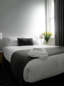 um quarto com uma grande cama branca e uma janela em Sunnyside Tavern em Newcastle