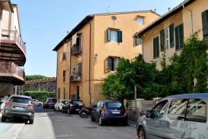 uma rua com carros estacionados ao lado de um edifício em La casa di Dario, Dario's house. em Pisa