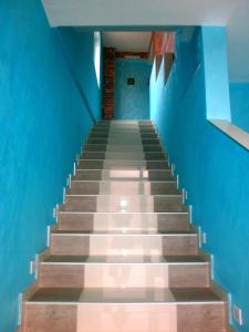uma escada com paredes azuis e uma parede azul em Apartmani Spasic em Leskovac