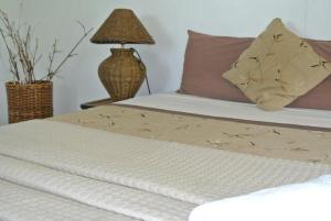 um close-up de uma cama com um abajur sobre uma mesa em The Friendly North Inn em Labasa