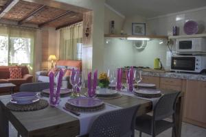 デルテブレにあるAlojamiento vacacional en el Delta del Ebroのキッチン(紫の皿とワイングラス付きのテーブル付)