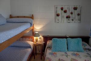 デルテブレにあるAlojamiento vacacional en el Delta del Ebroのベッドルーム1室(二段ベッド2台、ランプ付きテーブル付)