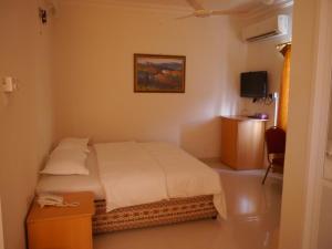 una camera da letto con un letto, un tavolo e una TV di Plaza Hotel a Mascate