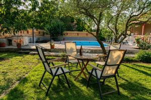 una mesa y sillas en un patio con una botella de vino en Vacation home Duilo, en Donji Zemunik