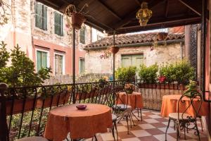 a patio with two tables and chairs on a balcony at Ca' del Cinema B&B in Venice