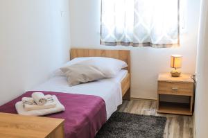 a small bedroom with a bed with towels on it at Apartment Petar in Kaštela
