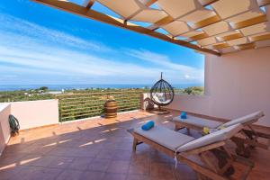 a patio with a couch and a table on a balcony at NV Luxury Villa in Kyparissia