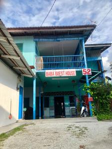 une maison d'hôtes baja avec un bâtiment bleu dans l'établissement Baba's Guest House By The Sea, à Batu Ferringhi