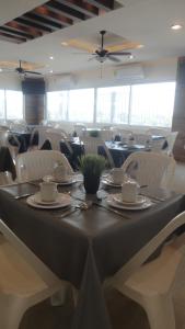 a dining room with a table and white chairs at Hotel Tampico Express in Ciudad Madero