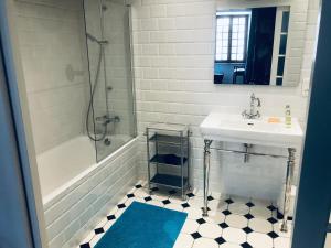 een witte badkamer met een wastafel, een bad en een wastafel bij B&B du Cloître in Tréguier