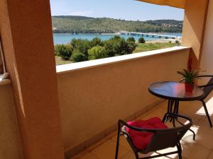 a balcony with a table and chairs and a view of the water at Apartments Nika in Trogir