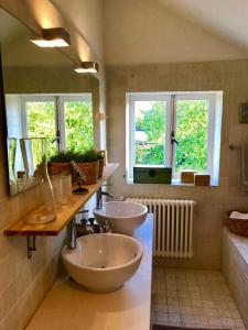 a bathroom with two sinks and two mirrors at Charming countryhouse near Amsterdam in Abcoude