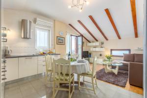 a kitchen and a living room with a table and chairs at Korina in Kostrena