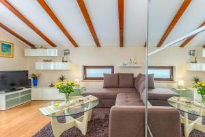 a living room with a couch and a tv at Korina in Kostrena