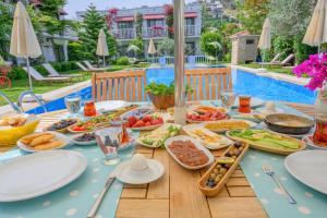 a table with food on it next to a pool at Villa Rustica Hotel in Gundogan