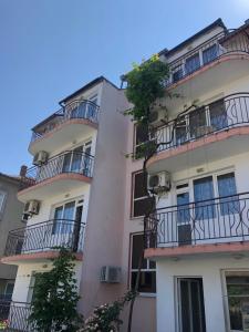 an apartment building with balconies on the side of it at Хотел Милев in Kiten