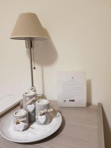 einen Tisch mit drei Kaffeetassen und einer Lampe darauf in der Unterkunft Villa Degli Ulivi in Santa Maria del Cedro