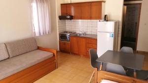 a small kitchen with a couch and a refrigerator at Erofili in Pefkochori +11 photos