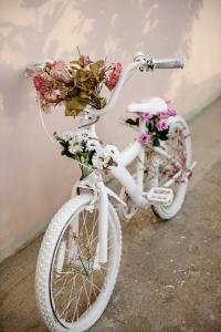 een witte fiets met bloemen erop geparkeerd tegen een muur bij Villa Irene in Kalymnos